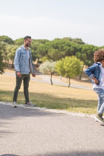 A diverse family enjoys playing soccer in a sunny park in Portugal, capturing fun and bonding.